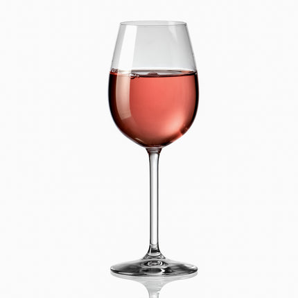 Copa con un vino rosado natural sobre un fondo blanco.