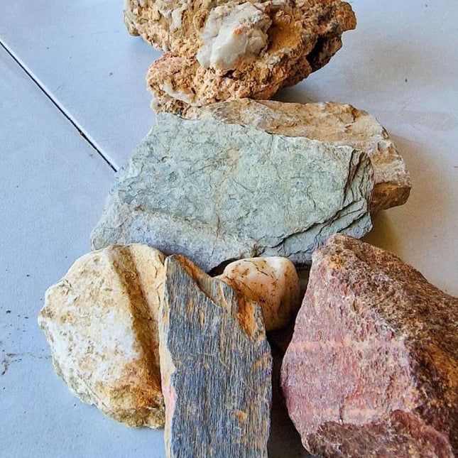 Piedras de diferentes colores y texturas sobre una mesa, utilizadas para ilustrar la composición del suelo en el viñedo de Corullón.