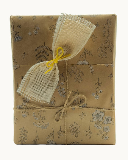 Caja de regalo de productos artesanales gallegos, envuelta en papel Kraft y con un lazo rústico.