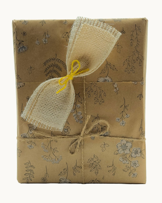 Caja de regalo de productos artesanales gallegos, envuelta en papel Kraft y con un lazo rústico.