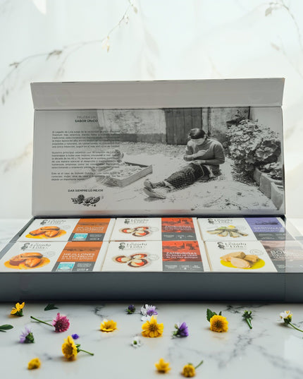 Una caja de conservas edición limitada sobre una mesa de mármol con flores