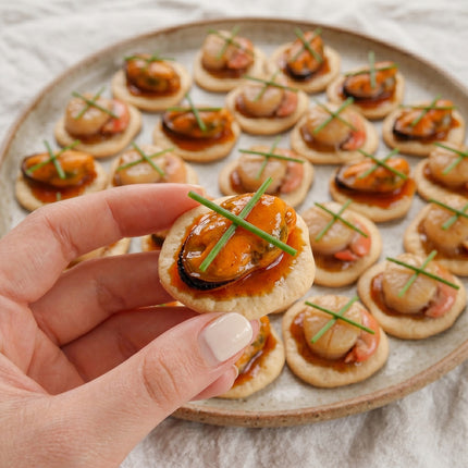 Canapés gourmet de zamburiñas en salsa de vieira y mejillones en escabeche sobre galletas mariñeiras para aperitivo