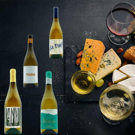 Pack de 4 vinos de España, 2 son vinos ecológicos de Galicia, uno es Palomino y el otro es Malvasia. Sobre una mesa negra con quesos y copas de vino.