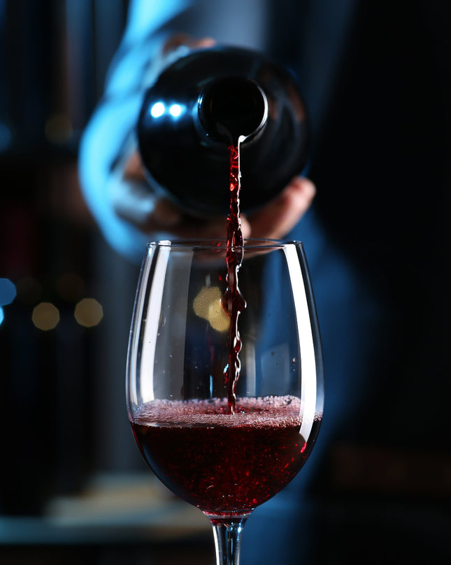Una persona sirviendo una copa de vino tinto Gallego de Mencía