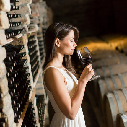 Una chica con un catando un vino tinto en el cellar de una bodega en Galicia