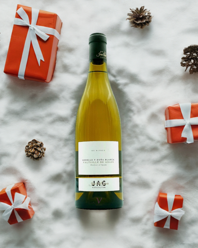 Vino Orgánico Godello y Doña blanca sobre la nieve con regalos Navideños al lado.