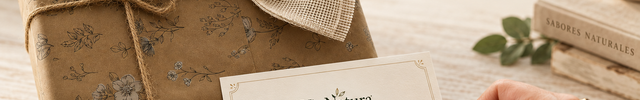 Tarjeta VinNatura con mensaje personalizado escrita a mano junto a una caja regalo envuelta en papel Kraft y lazo rústico en formato horizontal