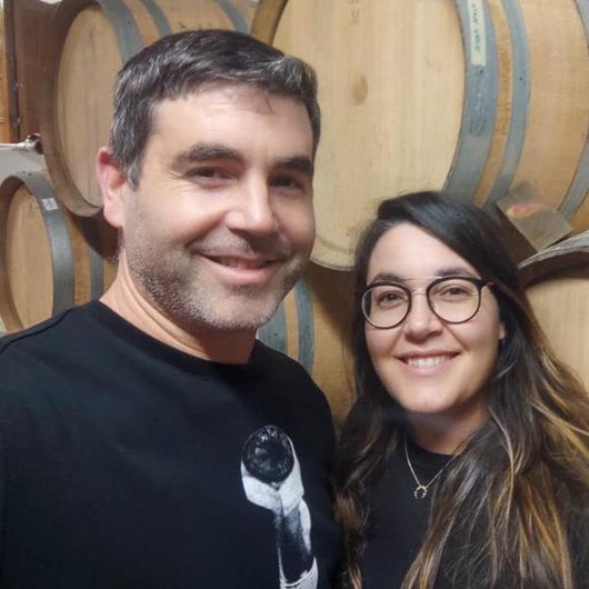 Retrato de Jorge y Saleta en su bodega Saiñas, en Galicia. Con unos barriles de vino tinto Mencía al fondo.