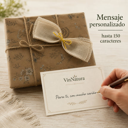 Tarjeta VinNatura con mensaje personalizado escrita a mano junto a una caja regalo envuelta en papel Kraft y lazo rústico