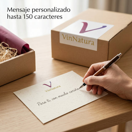 Tarjeta VinNatura con mensaje personalizado escrito a mano junto a una caja gourmet preparada para enviar como regalo