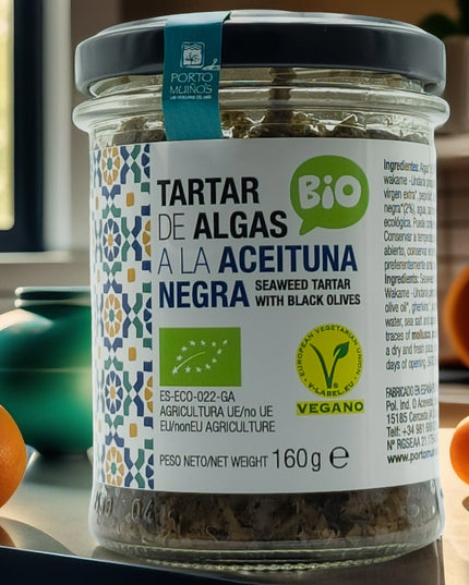Tarro de tartar de algas con aceituna negra sobre una cocina