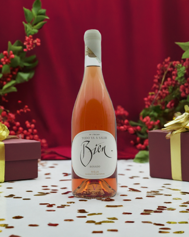 Vino rosado Todo Va a Salir Bien 2023 sobre una mesa blanca y regalos de navidad.