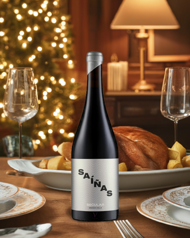 Vino tinto Gallego de Mencía, Secular 2021 en una mesa con copas y un pavo asado, en un ambiente Navideño con un árbol decorado de Navidad con las luces encendidas.