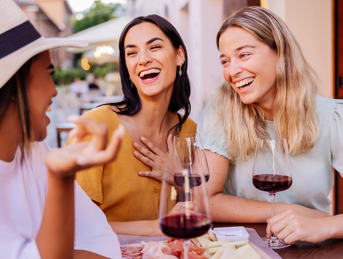 Amigas bebiendo un vino natural Gallego tinto en un restaurante en un día soleado Otoñal.